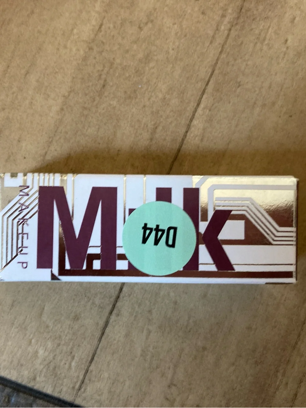 Milk Makeup lipstick packaging in white and burgundy with mint label